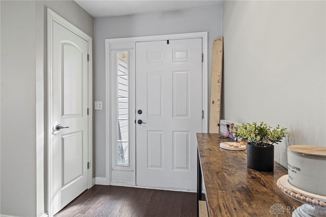 entryway featuring dark wood finished floors and baseboards