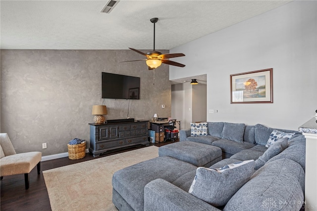 living area with visible vents, a ceiling fan, vaulted ceiling, wood finished floors, and baseboards