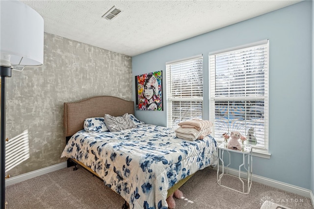 carpeted bedroom featuring baseboards, visible vents, and a textured ceiling