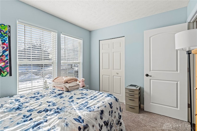 bedroom featuring a textured ceiling, a closet, and light carpet