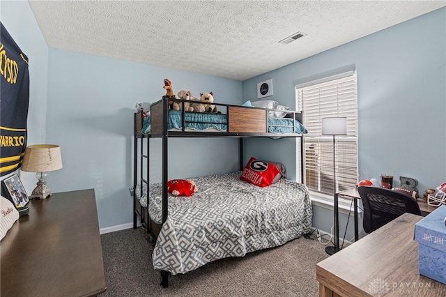 bedroom with visible vents, carpet flooring, a textured ceiling, and baseboards