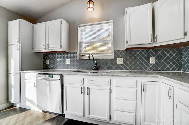 kitchen with vaulted ceiling, dishwasher, sink, and white cabinets