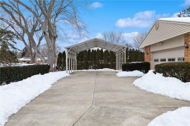 view of snow covered exterior featuring a garage and a carport