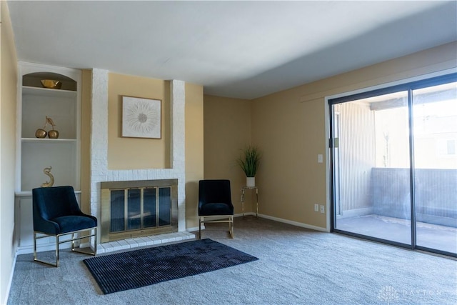 sitting room with baseboards, carpet, and a brick fireplace