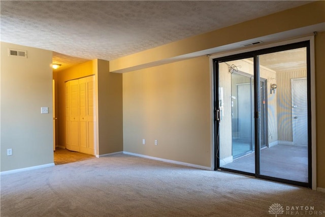 empty room featuring light carpet and a textured ceiling