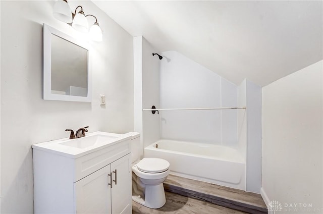 full bathroom with lofted ceiling, toilet, wood-type flooring, vanity, and shower / washtub combination