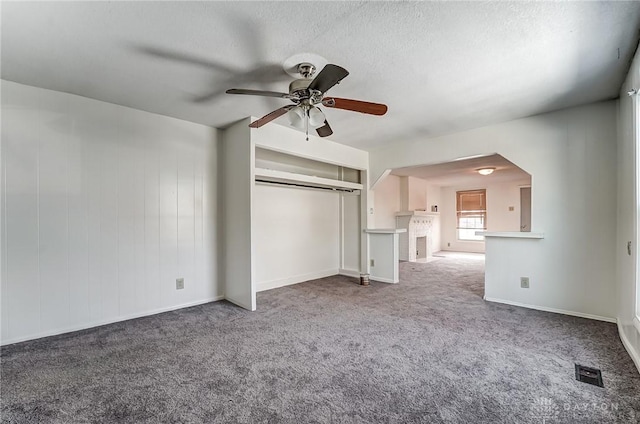 unfurnished bedroom with ceiling fan, carpet flooring, a closet, and a textured ceiling