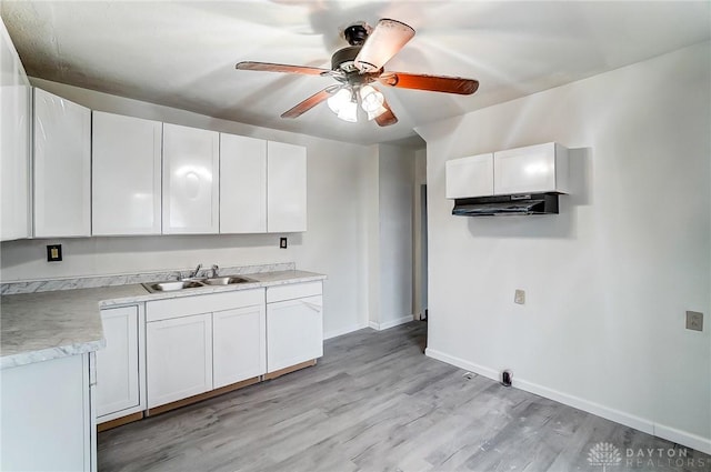 kitchen featuring white cabinetry, light hardwood / wood-style floors, and sink