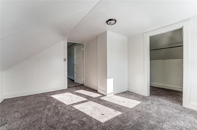 unfurnished bedroom featuring lofted ceiling and carpet flooring