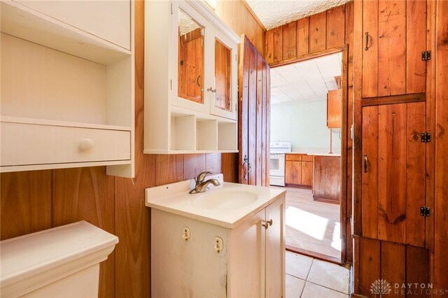 bathroom featuring vanity, tile patterned floors, and wood walls