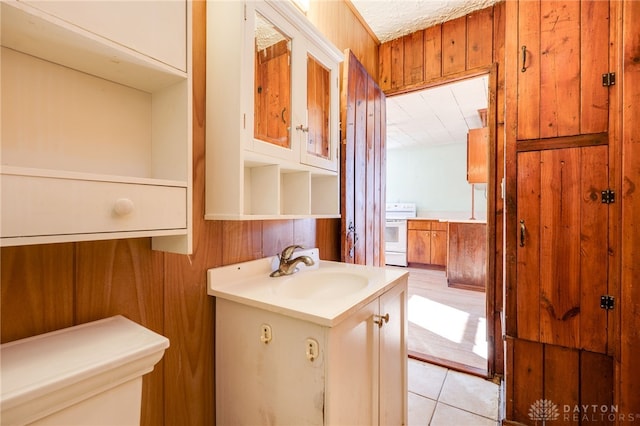 bathroom featuring tile patterned flooring, vanity, and wood walls