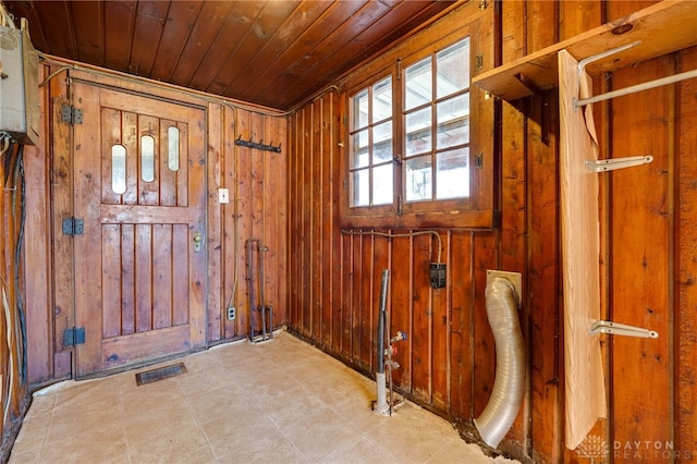 foyer entrance featuring wooden ceiling and wood walls