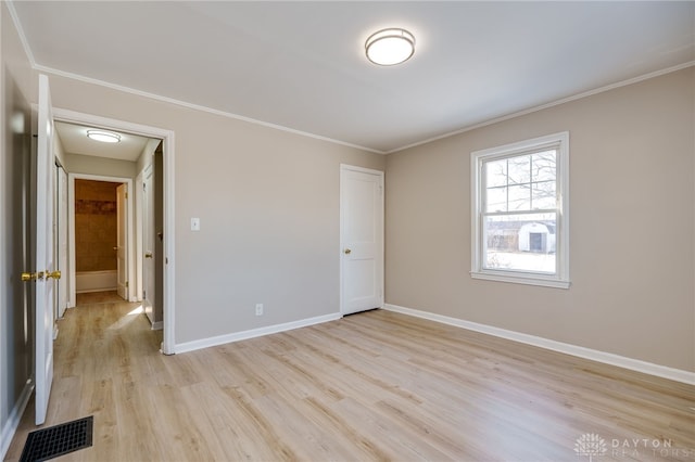 unfurnished bedroom with crown molding and light hardwood / wood-style floors