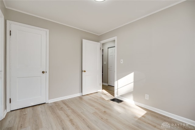 unfurnished bedroom with ornamental molding and light hardwood / wood-style floors