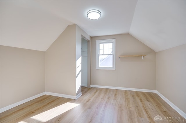 bonus room with lofted ceiling and light wood-type flooring