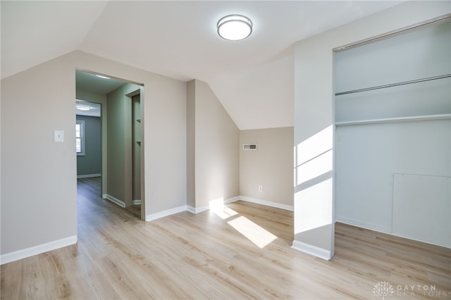 additional living space featuring light hardwood / wood-style flooring and vaulted ceiling