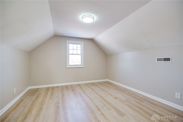 additional living space with lofted ceiling and light hardwood / wood-style flooring