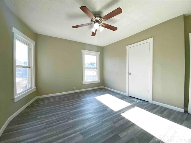 spare room with dark hardwood / wood-style floors and a textured ceiling