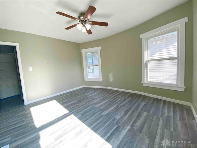 empty room with dark wood-type flooring and ceiling fan