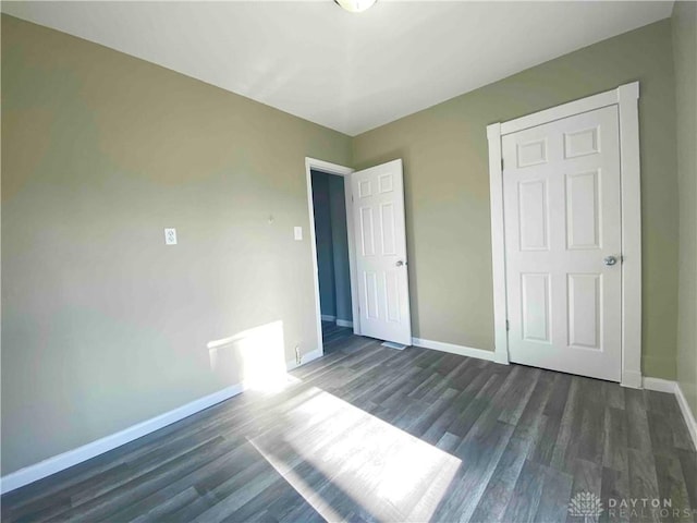 unfurnished bedroom with dark hardwood / wood-style flooring