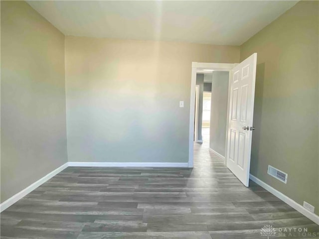 spare room featuring dark wood-type flooring