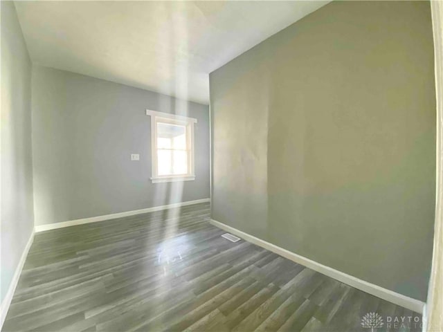 unfurnished room with dark hardwood / wood-style flooring