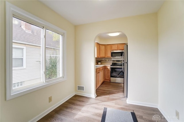 kitchen with stainless steel appliances and light hardwood / wood-style floors