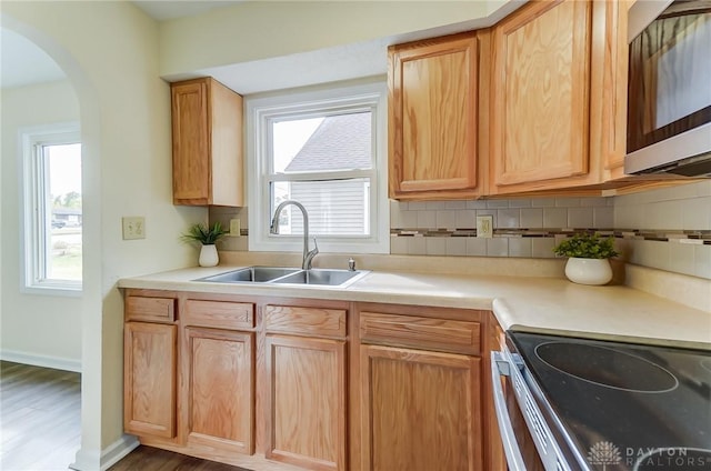 kitchen featuring sink, decorative backsplash, wood-type flooring, and plenty of natural light