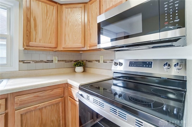 kitchen featuring backsplash, stainless steel appliances, and light brown cabinets