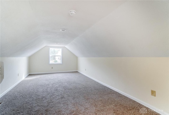 additional living space with lofted ceiling and carpet flooring