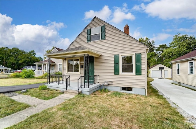 bungalow-style house with a garage, an outdoor structure, a front yard, and a porch