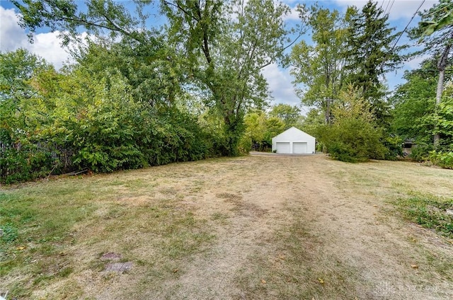 view of yard featuring a garage and an outdoor structure