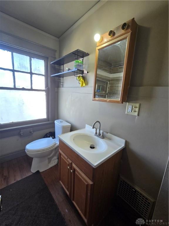 bathroom with vanity, hardwood / wood-style flooring, ornamental molding, and toilet