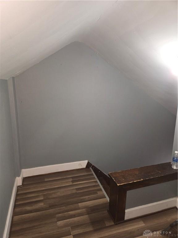 stairs with hardwood / wood-style flooring and lofted ceiling