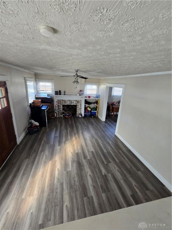 unfurnished living room featuring dark wood-type flooring, a fireplace, and a textured ceiling