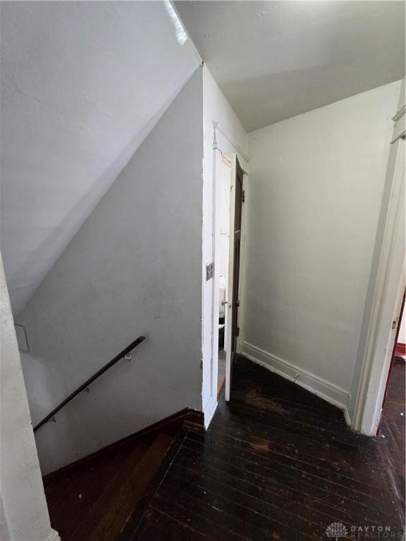 stairs with hardwood / wood-style flooring and vaulted ceiling