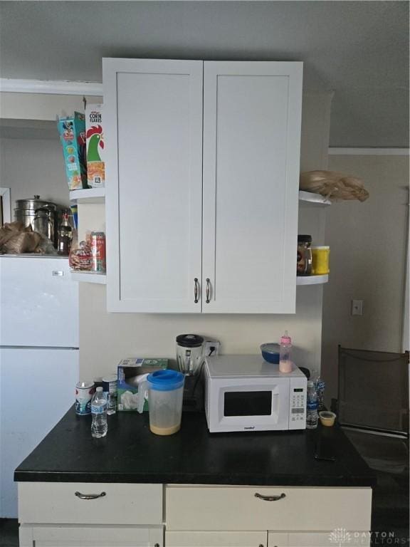 kitchen featuring white cabinets and white appliances