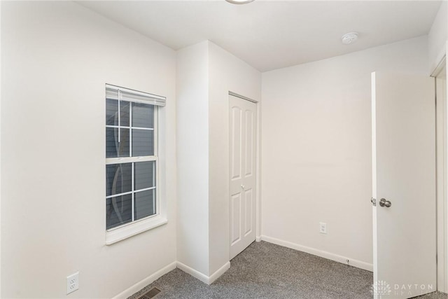 unfurnished bedroom featuring carpet flooring and a closet