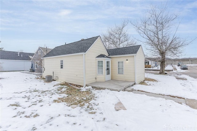 snow covered rear of property featuring cooling unit