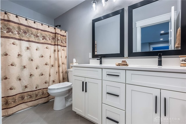 bathroom featuring vanity, tile patterned flooring, and toilet