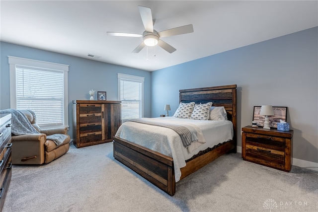 carpeted bedroom with multiple windows and ceiling fan