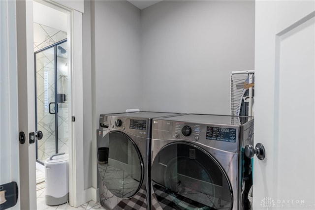 washroom featuring independent washer and dryer and light tile patterned flooring