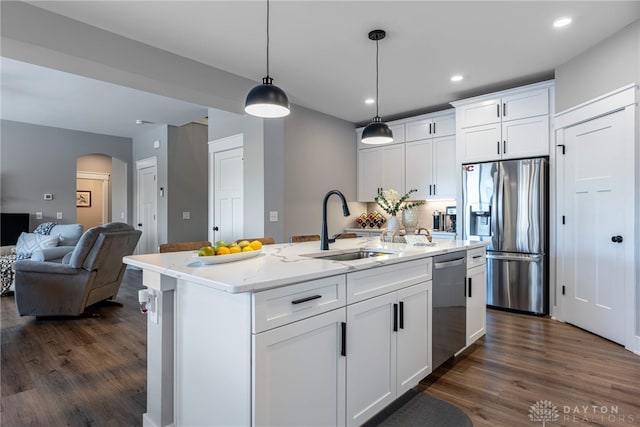 kitchen with decorative light fixtures, white cabinetry, an island with sink, sink, and stainless steel appliances