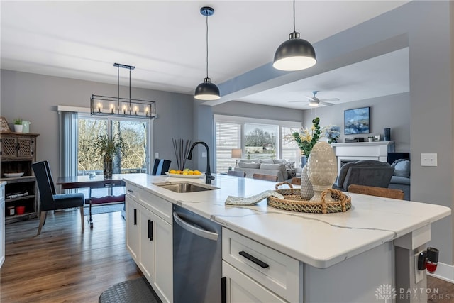 kitchen with sink, dishwasher, a kitchen island with sink, hanging light fixtures, and white cabinets