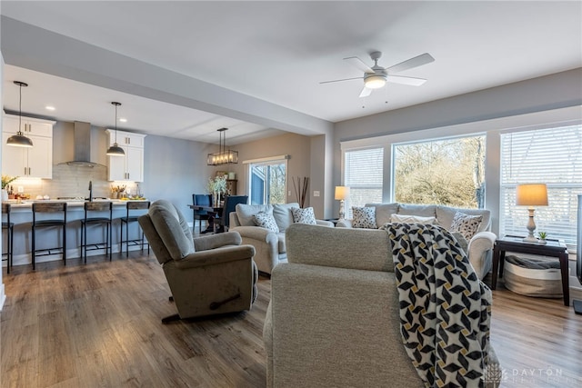 living room featuring dark hardwood / wood-style floors and ceiling fan with notable chandelier