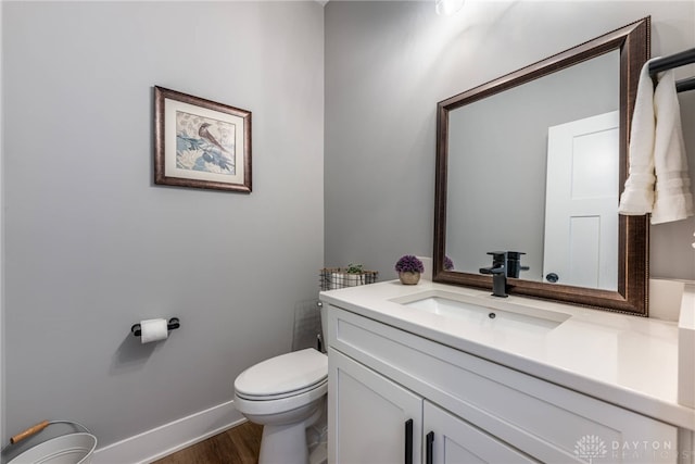 bathroom with vanity, hardwood / wood-style floors, and toilet