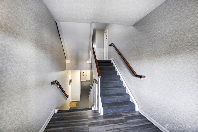 staircase with a textured ceiling