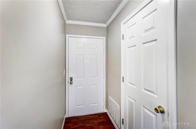 doorway featuring crown molding, dark hardwood / wood-style flooring, and a textured ceiling