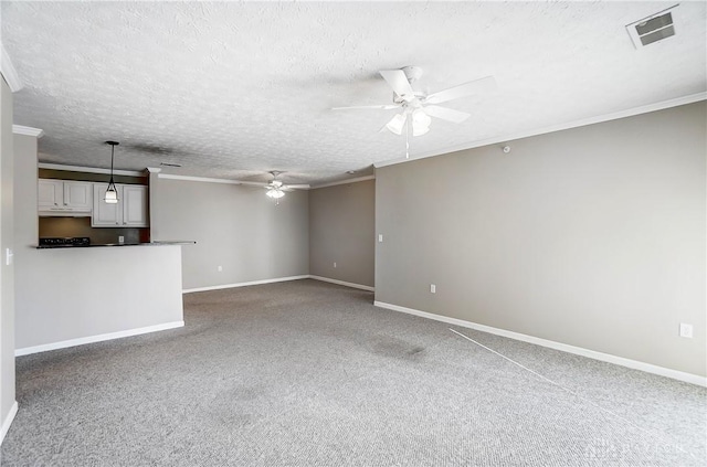 unfurnished living room with ornamental molding, carpet floors, a textured ceiling, and ceiling fan