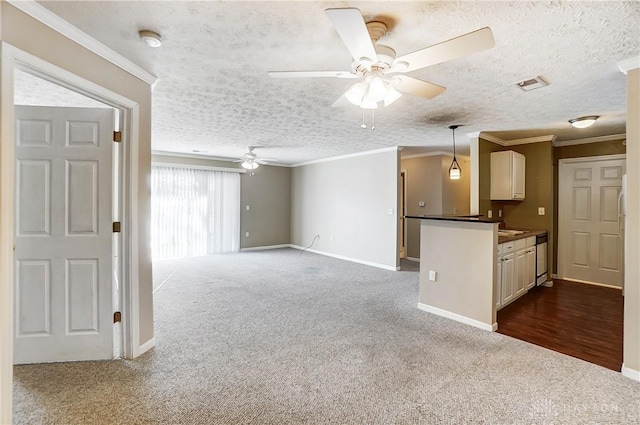 unfurnished living room featuring ornamental molding, carpet floors, ceiling fan, and a textured ceiling